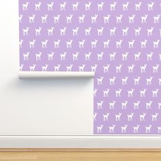 a purple wallpaper with white deer silhouettes on it in front of a door