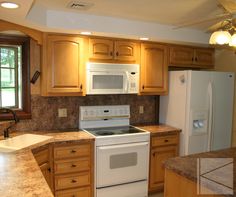 a kitchen with wooden cabinets and white appliances