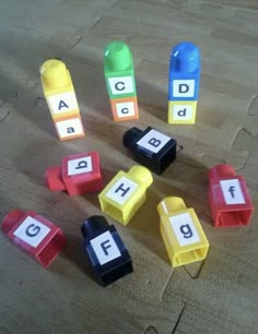 several different colored blocks with letters and numbers on them sitting on a table next to each other