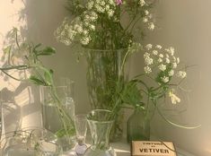 several vases with flowers in them sitting on a table next to a sign that says vetiver