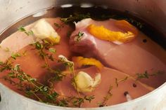 a pot filled with meat and vegetables on top of a stove next to an orange peel