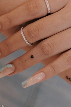 two hands with manicured nails and rings on them, one has a diamond ring