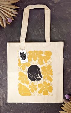 My beloved Lazy Cat print is now available on tote bags! 🐈 Perfect gift for your cat lover friend, or for yourself - a lovely tote bag for everyday errands 💛  ⭐ This print was designed by me and printed on tote bags by a local vendor here in BC using 2 color ink on the natural color of the cotton.  ⭐ Product details: The size is about 15X16 inches with 22" handles. Print size is approximately 10x12 inches.  Design is printed on one side of the bag.   ⭐ Materials: The tote bags are made of organic cotton and are natural color. Cold wash recommended to maintain the colors and keep the bag in best condition. Cat Tote Bag, Cats Tote Bag, Cat Flowers, Lazy Cat, Cat Tote, Yellow Cat, Canvas Designs, Cat Illustration, Linocut Prints