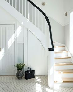 a black and white bag sitting on the floor next to a stair case