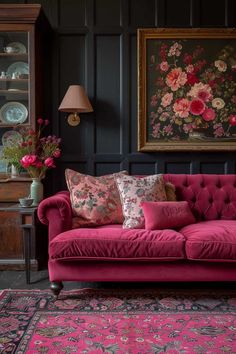 a living room with pink couches and rugs in front of black paneled walls