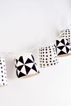 some black and white paper lanterns hanging from a string on the wall with polka dots