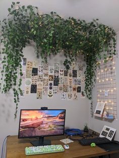 a desk with a computer, keyboard and monitor covered in ivys on the wall