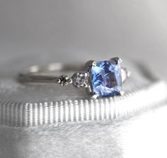 an engagement ring with a blue stone and three diamonds