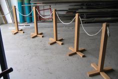 four wooden poles with ropes attached to them in a warehouse area next to other equipment