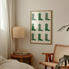 a bedroom with white walls and green cowboy boots on the wall next to a bed