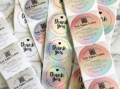 thank you stickers are on top of some white and pink envelopes that say thank you