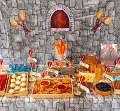 a table topped with lots of food next to a stone wall