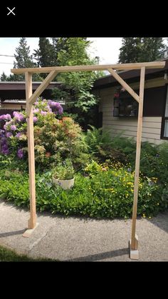 a wooden arbor in the middle of a garden