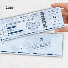 someone is holding up two tickets for their plane ride to save the date on them