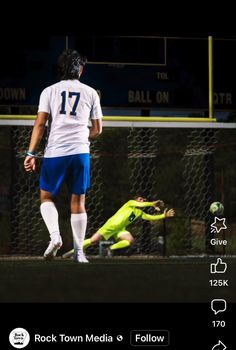 a soccer player is kicking the ball in front of another player on the field with his head down