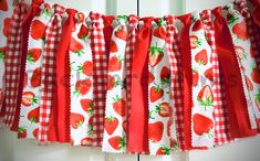 a red and white checkered curtain with strawberries on it