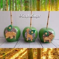 three green apples with animals on them sitting in front of some bamboo trees and the words graphik sugar