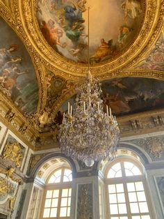 a chandelier hangs from the ceiling in an ornate room