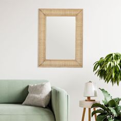 a living room with a green couch and mirror on the wall