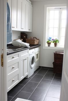 a washer and dryer in a small room with white cabinets on the walls