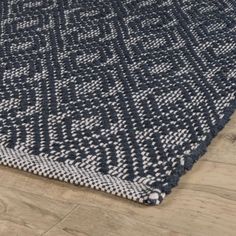 a blue and white rug on top of a wooden floor next to a wood floor