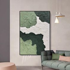 a green and white painting hanging on the wall in a living room next to a couch