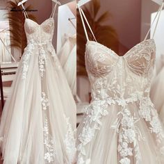 two dresses hanging up in a store with white flowers on the boudoirs