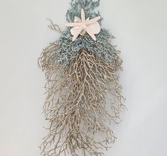 a white starfish on top of some blue and silver seaweed with corals attached to it