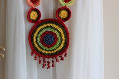 a crocheted necklace hanging on a curtain