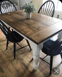 a dining room table with two chairs and a potted plant on top of it