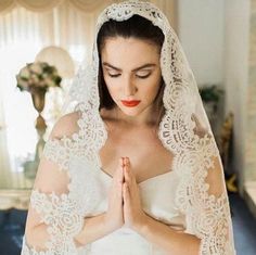 a woman wearing a veil and holding her hands together