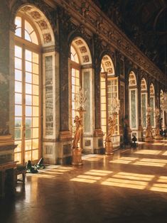 the sun shines through large windows in an ornately decorated room with statues and chandeliers