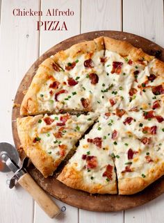 a pizza with cheese and bacon on a cutting board