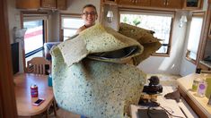 a woman standing in front of a large pile of blankets on top of a kitchen counter