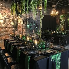 a table set up with black plates and green napkins for an elegant halloween party