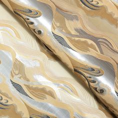 an abstract gold and silver fabric with wavy lines on it's surface, closeup