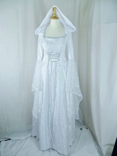 This dress will be made to the measurements that you send me. Please send me your bust, waist and hip measurements and please measure from the top of your shoulder to the floor with shoes on. It is made with beautiful white velvet and stunning heavy white bridal duchess with silver embroidered detailing. The sleeves are in part velvet with a lovely white embroidered organza. It has corset style front and back with lacing so you can adjust the dress to fit your body shape. Combined shipping on multiple items. If you purchase express shipping by courier please send me your phone number thank you. White Medieval Dress, Black White Wedding Dress, Medieval Wedding Dress, Simple White Dress, Medieval Wedding, White Cocktail Dress, Embroidered Organza, Black White Wedding, Fantasy Gowns