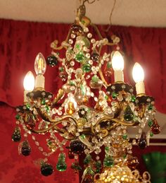 a fancy chandelier hanging from the ceiling in a room with red walls and curtains