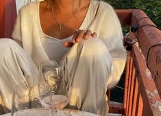 a woman sitting at a table with wine glasses