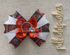 an orange and white bow with a football helmet on it