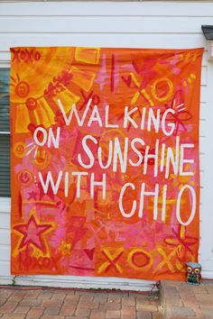 an orange and pink banner that says walking on sunshine with chio