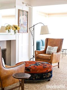 a living room filled with furniture and a fire place next to a wall mounted fireplace