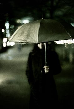 a person holding an umbrella in the dark