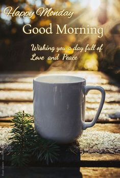 a white coffee cup sitting on top of a wooden table with the words happy monday good morning