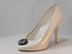 A small and glamorous ceramic high heel shoe with Ivory rainbow luster glaze. This piece is 7.5" long x 2.75" wide x 5" tall. The inside rim is painted gold. The toe has a 1" diameter Black lucite cabochon with white enameled radiating grooves. The shoe is open, so could potentially hold small items. A sweet and different ceramic piece. Pottery Rainbow, Ceramic Shoes, Tyler Tx, Vintage Studio, Studio Pottery, White Enamel, High Heel Pumps, Small Items, Collectible Figurines