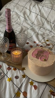 a birthday cake and champagne on a bed with confetti