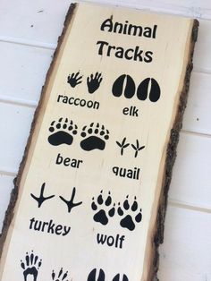 a wooden sign with animal tracks on it