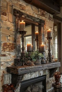 a fireplace with candles on top of it in front of a mirror and stone wall