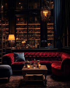 a living room with red couches and candles on the coffee table in front of it