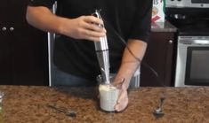 a man is mixing something in a blender